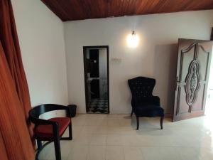a living room with a chair and a table at NS Apartments in Dalugama