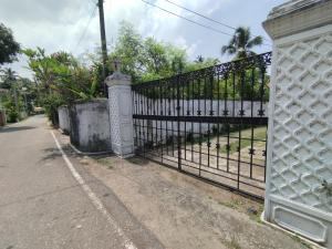 an ornate metal fence with a gate on a street at NS Apartments in Dalugama