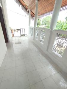 a room with white tile floors and a wooden ceiling at NS Apartments in Dalugama