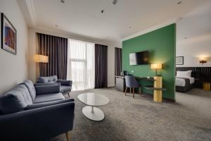 a living room with a couch and a table in a hotel room at Pine Astoria Hotel in Tbilisi City