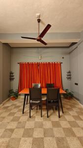 a dining room table with chairs and a ceiling fan at Casa pinto Valencia and The Second Storey in Mangalore