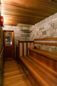 a empty room with a stone wall and wooden benches at 24時間源泉かけ流しを ひとりじめできる 一棟貸しVilla安曇野 in Azumino