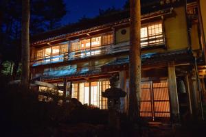 a lit up building with windows and a balcony at 24時間源泉かけ流しを ひとりじめできる 一棟貸しVilla安曇野 in Azumino +35 photos