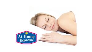 a woman sleeping on a bed with a sign at home express at At Home Express Tangerine Inn in De Land