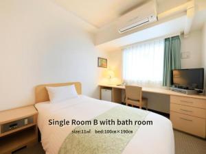 a hotel room with a bed and a desk with a computer at Hotel Famy Inn Kinshicho in Tokyo