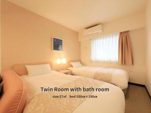 a hotel room with two beds and a window at Hotel Famy Inn Kinshicho in Tokyo
