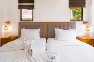 two beds sitting next to each other in a bedroom at Casa Verde Cliff Resort & Spa in Camotes Islands