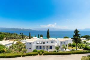 a large white house with the ocean in the background at Porto Galini Seaside Resort & Spa in Nikiana