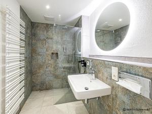 a bathroom with a sink and a mirror at Apartments am Linggplatz - Ruhige Lage in der Fußgängerzone - Self-Check-in - Parkhaus inklusive - Schnelles WLAN in Bad Hersfeld
