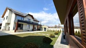 a large house with a yard with a lawn sidx sidx sidx at Pensiunea SOLEA in Ucea de Jos