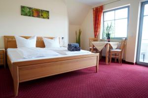 a bedroom with a large bed and a table with a table at Weingut Martin Blaß in Erlabrunn