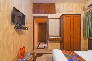 a room with a bed and a tv on a wall at FabHotel Step Inn Stays in Ballygunge