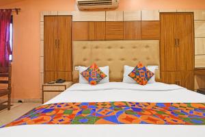 a bedroom with a large bed with colorful pillows at FabHotel Step Inn Stays in Ballygunge