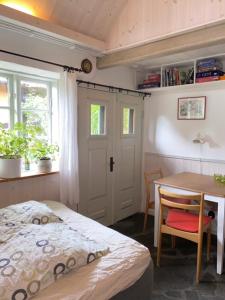 a bedroom with a bed and a desk and a table at Alunbruket B & B in Brösarp +14 photos