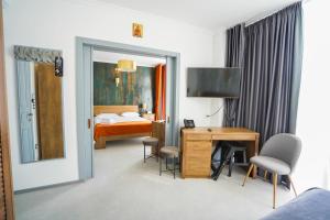 a hotel room with a bed and a desk with a television at HOTEL ANGEL SOFIA in Fălticeni