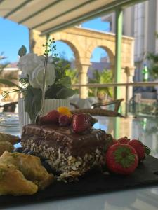 a piece of chocolate cake with strawberries on a table at Family Complex Gallery - Sunny Beach in Sunny Beach