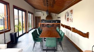 a dining room with a table and green chairs at Pensiunea SOLEA in Ucea de Jos