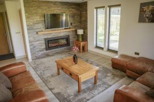 a living room with a couch and a fireplace at Oak Lodge in Knighton