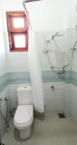 a bathroom with a toilet with a shower curtain at Villa 86 in Pamunugama