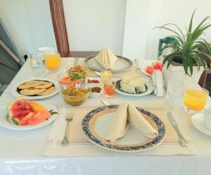 a white table with plates of food on it at Villa 86 in Pamunugama +3 photos