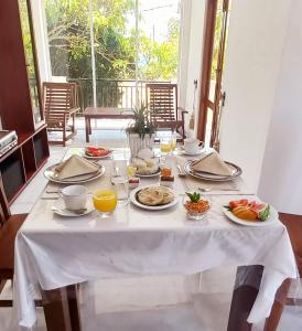 a table with plates of food on top of it at Villa 86 in Pamunugama