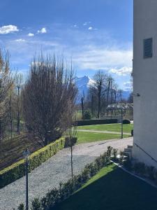 a walkway leading into a park with mountains in the background at L'Orangerie del Castello in Morozzo +10 photos