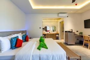 a toy frog sitting on a bed in a room at Cote d'Or Retreat in Anse Volbert Village