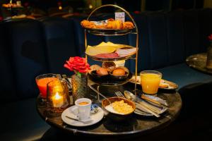a table with a tray of breakfast foods and drinks at Supper Boutique Suites in Amsterdam