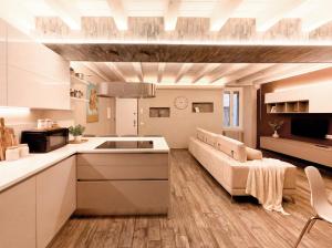 a kitchen and living room with a couch and a table at Iseo Lake Luxury Duplex - Centro & Design in Iseo