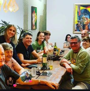 a group of people sitting around a table with drinks at Hotel Pousada Villa Monnaié centro in Chapada dos Guimarães