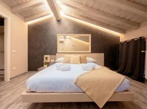 a bedroom with a large bed with white sheets at Iseo Lake Luxury Duplex - Centro & Design in Iseo +7 photos