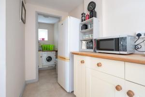 a kitchen with a microwave and a washer and dryer at The Studio in Somerton