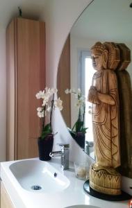 a bathroom with a statue next to a sink at Chambre double 30km de la Tour Eiffel in Saint-Michel-sur-Orge