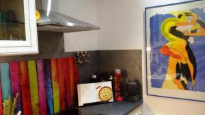 a kitchen counter with a painting of a woman at Chambre double 30km de la Tour Eiffel in Saint-Michel-sur-Orge +4 photos