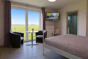 a bedroom with a bed and a table with chairs at B&B Het Polderhof in Jabbeke