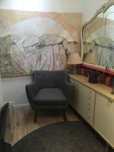 a living room with a chair and a painting on the wall at Chambre double 30km de la Tour Eiffel in Saint-Michel-sur-Orge