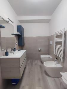 a white bathroom with a sink and a toilet at Yellow Dream B&B 2 in Torre Melissa +13 photos