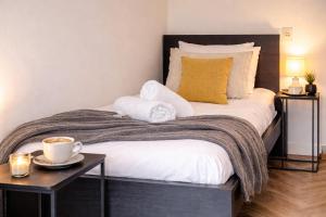 a bedroom with a bed with a coffee cup and two tables at Budget-Friendly Room Tilburg Center Prime Loc in Tilburg