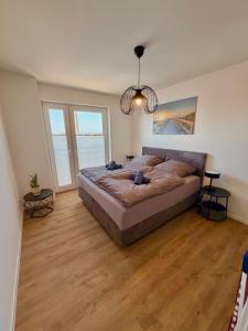 a large bedroom with a large bed and wood floors at Maritime Suite an der Geeste in Bremerhaven