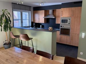 a kitchen with wooden cabinets and a dining table at Duplex vernieuwd appartement Dujardin bubbelbad in Blankenberge
