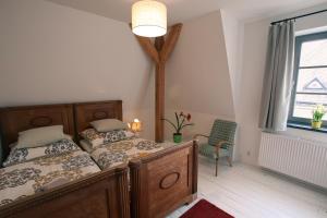a bedroom with two beds and a chair and a window at Vila Krocinka in Prague