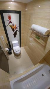 a bathroom with a toilet and a bath tub at Boracay Haven Suites in Boracay