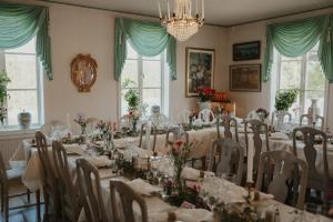 a dining room with tables and chairs with flowers on them at Bångbro Herrgård in Kopparberg