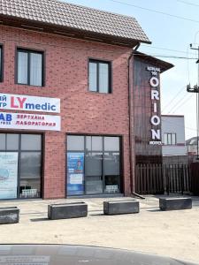 a brick building with a sign in front of it at Orion Hotel in Almaty +8 photos