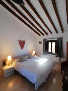 a bedroom with a large white bed with two lamps at Finca Guillermo Murcia in Cañada del Trigo