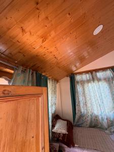 a room with a wooden ceiling and two windows at Walking Trails homestay in Baragrān +11 photos