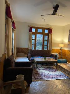 a living room with a couch and a table at Walking Trails homestay in Baragrān