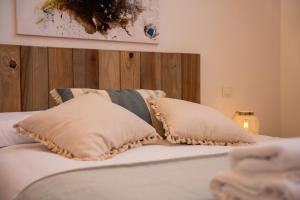 a bed with two pillows on top of it at El loft del sardi in Santander
