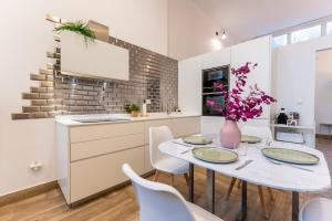 a kitchen with a table with chairs and a vase with flowers at El loft del sardi in Santander +8 photos