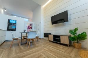 a living room with a table and chairs and a tv at El loft del sardi in Santander